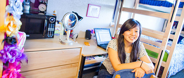 female student in her dorm room studying