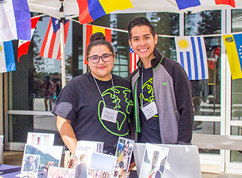 Students at a booth with international flags