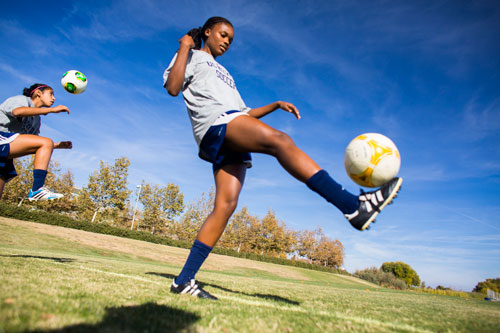 Two athletes practicing their soccer skills on a field. 