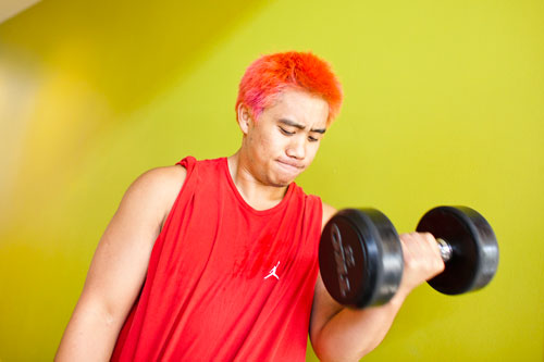 A student performing an exercise using a dumbbell 