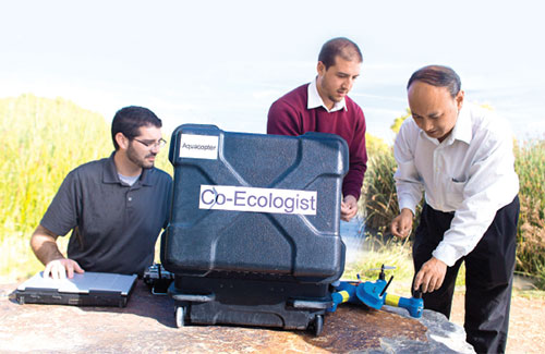 3 people part of a Ecologist Research team works with a drone