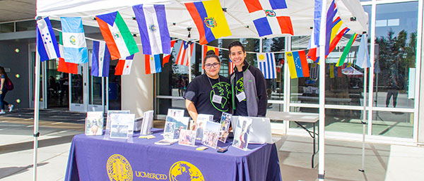 students at booth with multinational flags